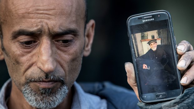Omar Nabi, brother of Yama, holds a photo of his father Haji Daoud, who was killed in the attack.