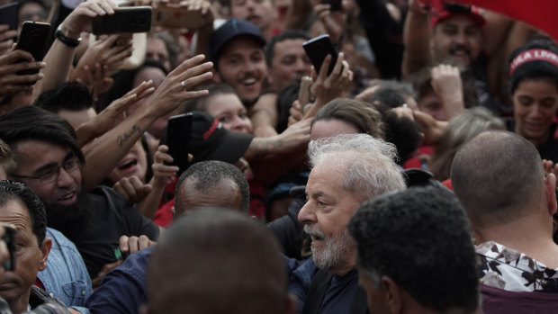 Brazil's former president Luis Inacio Lula da Silva, bottom, is mobbed by supporters as he is freed on Friday.