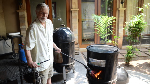 Ronald Craig Flint, widely known as Bubba, uses his "Texas torch" to get his barbecue started to smoke four chickens.