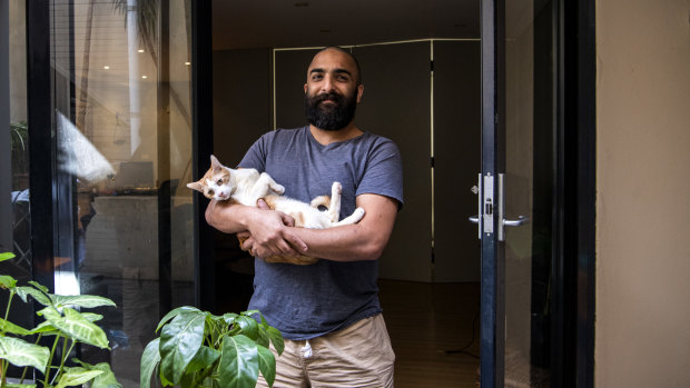 Sebastien Khavari with his foster cat at his home in Paddington.