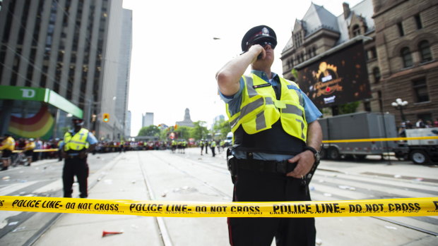 Police secure the scene after shots were fired at the parade.