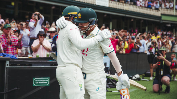 David Warner and Usman Khawaja hug before going out to open Australia’s second innings on Saturday.