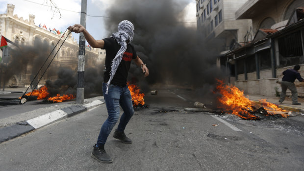 Palestinians sling stones during clashes with Israeli troops.