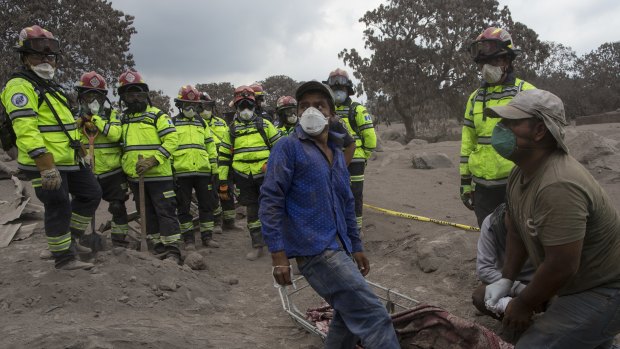 People try to identify the body of a relative who died in the disaster zone in the El Rodeo on Tuesday.