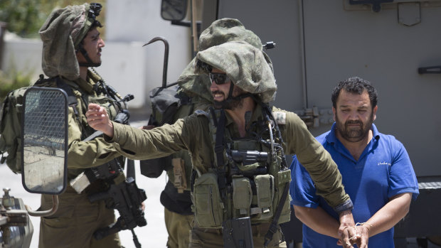 Israeli soldiers make one of several arrests of Palestinians last month after a soldier was killed by a rock thrown from a rooftop in the West Bank village of Yabad. 
