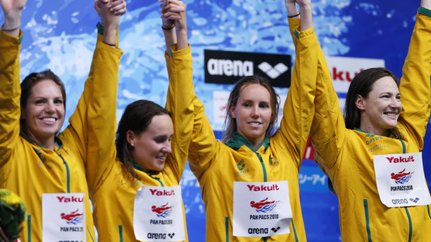 The Australian team celebrate on the podium after winning the women's 4x100m medley relay final.