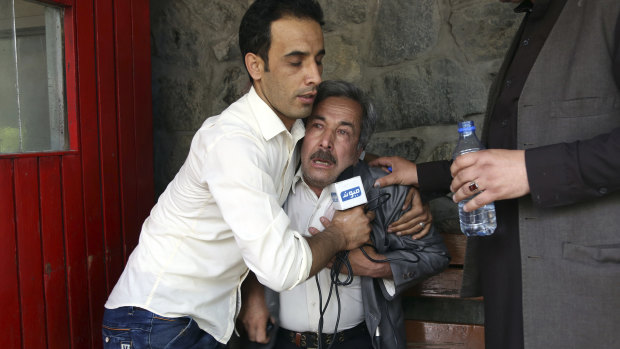 A man cries at a hospital after he lost his journalist son in an explosion in Kabul.
