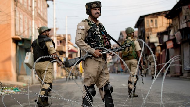 Indian paramilitary soldiers stand guard during curfew in Srinagar on August 7.