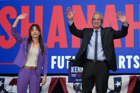 Presidential candidate Robert F. Kennedy Jr. right, waves on stage with Nicole Shanahan, after announcing her as his running mate.