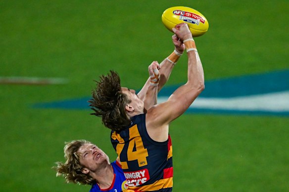 Crows defender Josh Worrell leaps for a mark.