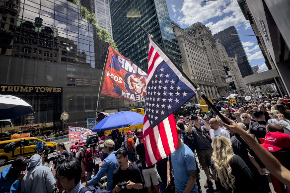 A Trump supporter waves an inverted American flag to protest against the verdict outside Trump Tower.