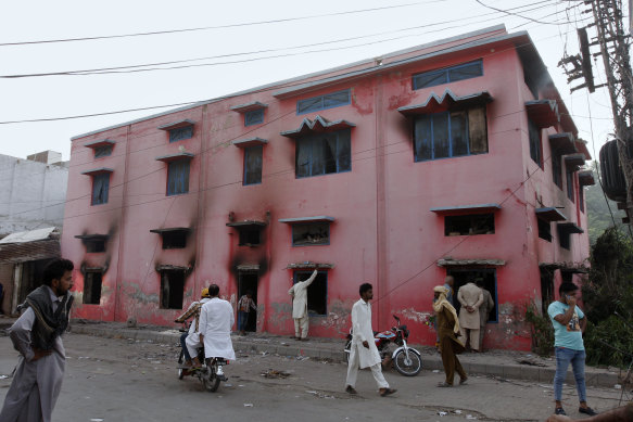 People look at a church damaged by angry Muslim mob in Jaranwala near Faisalabad, Pakistan.