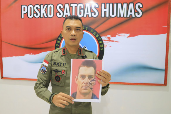 Bayu Suseno, a spokesperson for the Cartenz 2024 Peace Task Force, holds a portrait of Glen Malcolm Conning, a pilot for Indonesian aviation company PT Intan Angkasa Air Service.