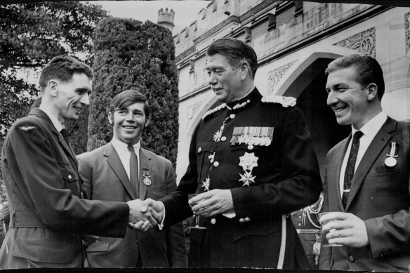 The then governor of NSW, Sir Roden Cutler, congratulates three men after decorating them for bravery. From left: aircraftman Kevin Wickerson, Private Richard Norden and Petty Officer William Young.