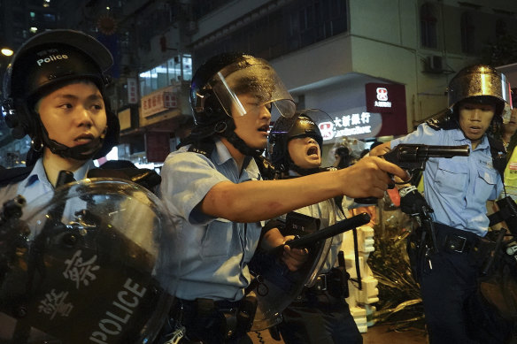 Police officers draw their weapons during a confrontation with protesters in Hong Kong on Sunday.