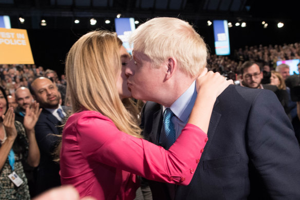 The Prime Minister exits the hall with his girlfriend Carrie Symonds following his keynote speech.