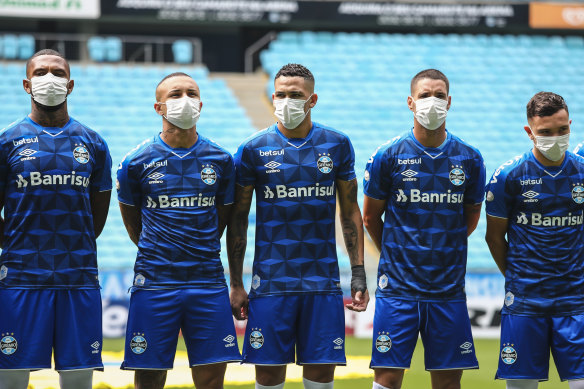 Gremio players take to the field in masks.