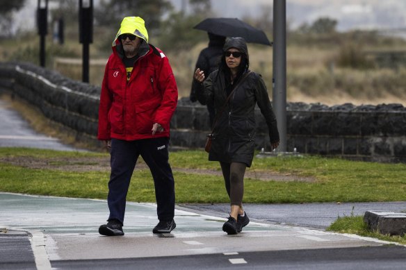 Walkers brave a wet day in Port Melbourne on Wednesday.