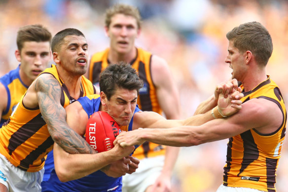 Matt Rosa, playing for West Coast, gets crunched by various Hawks in the 2015 grand final.