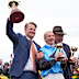 Jamie Melham holds her trophy with trainers Calvin and Tony.
