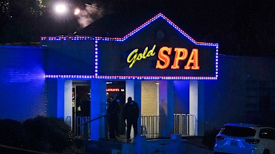 Law enforcement officials confer outside a massage parlor following a shooting in Atlanta.