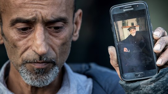 Omar Nabi, brother of Yama, holds a photo of his father Haji Daoud, who was killed in the attack.