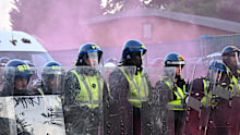 Riot police watch protesters as they gather in Southampton over the death of Henry Nowak.