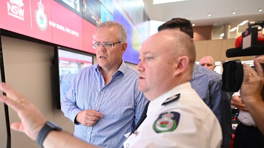 Prime Minister Scott Morrison is briefed by NSW RFS Commissioner Shane Fitzsimmons in the NSW Rural Fire Service control room in Sydney, Sunday, December 22, 2019. 