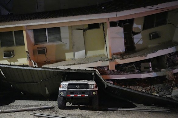 A vehicle lies crushed beneath a collapsed building after an earthquake struck Penonome in Panama.