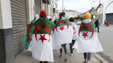 Demonstrators are draped in the Algerian flag during a rally in Algiers, on Friday. 