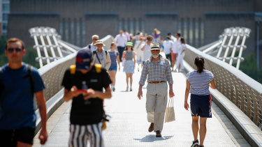 Pedestrians cross Londonâ€™s Millennium Bridge on so-called Freedom Day.