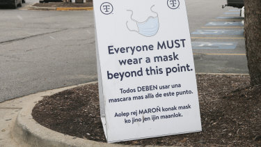 Znak w Springdale, Arkansas, przypominający pracownikom o założeniu maski przed wejściem na teren. 