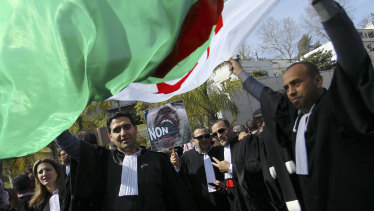 Algerian lawyers demonstrate with a national flag outside the constitutional council in a protest against President Abdelaziz Bouteflika.