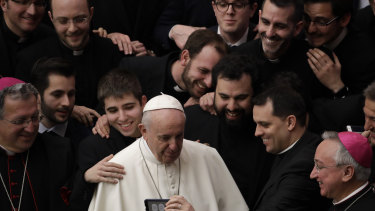 Pope Francis poses for a photo with a group of priests at the end of his weekly general audience on Wednesday.