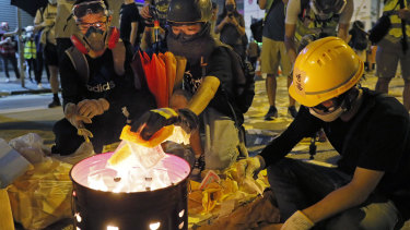 Protesters burn paper money to pay their respects for protesters who were injured on Aug 31 outside Prince Edward station in Hong Kong on Friday.