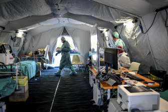 Medical personnel work inside an emergency structure set up in northern Italy to help ease the load on the country's groaning hospitals.