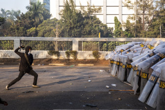 A student throws a rock at police in front of the People's Representative Council building in Jakarta.