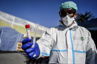 An Italian medico holds a coronavirus test kit outside a temporary medical facility set up to deal with coronavirus cases.