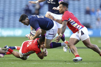 Scotland’s Sam Johnson is tackled by Tonga’s James Faiva.