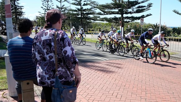 A couple watch as cyclists train ahead of the world road cycling championships in Wollongong.