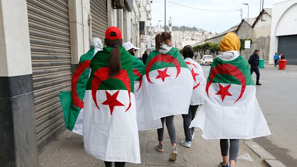 Demonstrators are draped in the Algerian flag during a rally in Algiers, on Friday. 