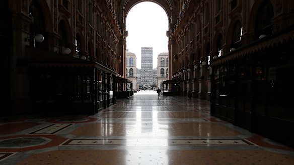 A woman walks in the empty Vittorio Emanuele II gallery shopping arcade in downtown Milan, Italy.