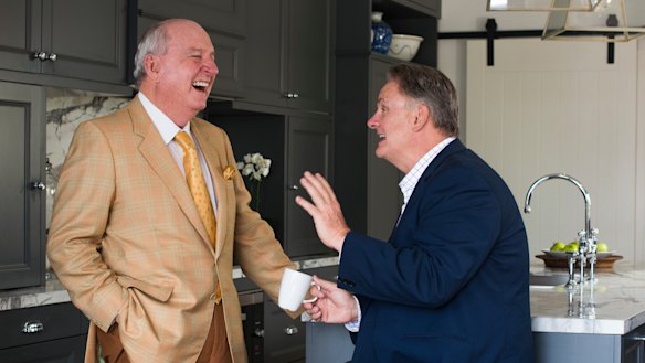 Alan Jones and Mark Latham enjoy a chat in a kitchen.