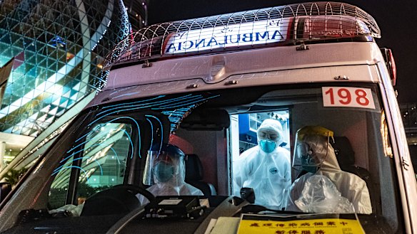 An ambulance stops outside the Grand Lisboa Hotel in Macau, where casinos will close for two weeks.