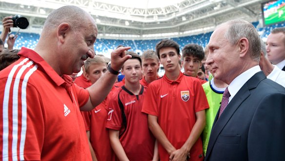 Russian President Vladimir Putin listens to Russia's head coach Stanislav Cherchesov as he visits the Kaliningrad Stadium after the 2018 World Cup.