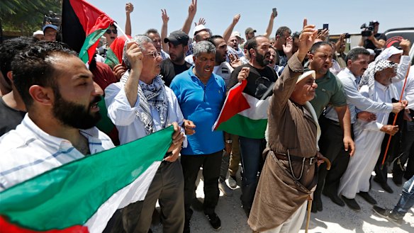 Palestinians hold flags during a protest in Khan al-Ahmar, last week. 