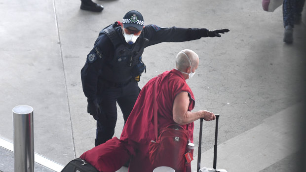 A police officer directs a returning passenger on the special Nepal Air flight.