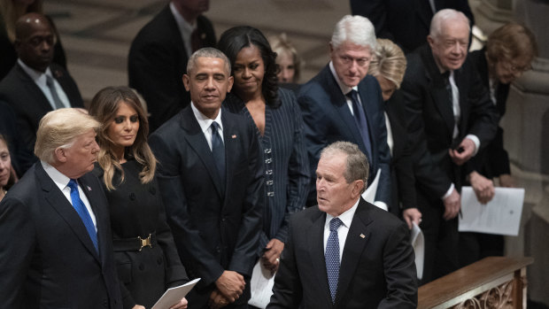 Former president George W. Bush walks to his seat after greeting President Donald Trump, first lady Melania Trump, former president Barack Obama, Michelle Obama, former president Bill Clinton, former secretary of state Hillary Clinton, former president Jimmy Carter and Rosalynn Carter during a state funeral for former president George H.W. Bush.