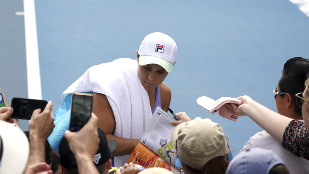 Barty signs autographs for fans after her training session on Monday.