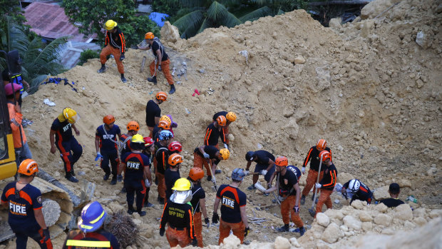Rescuers dig through the rubble to search for possible survivors following a landslide that buried dozens of homes in Naga city, Cebu province central Philippines.